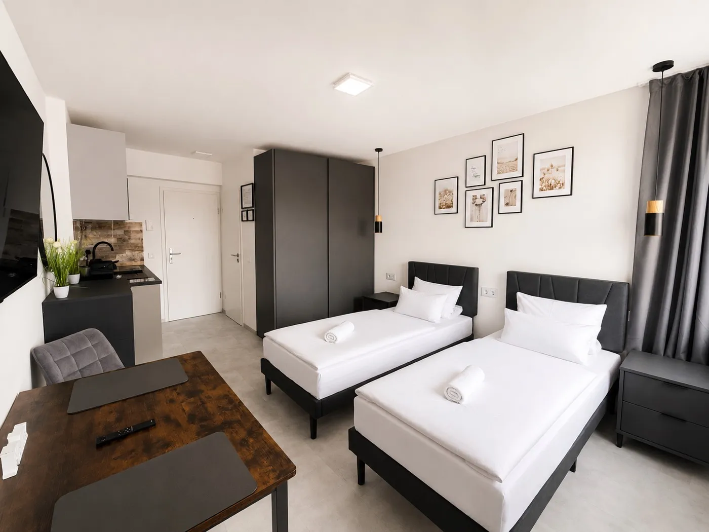Offener Wohnbereich mit Einzelbetten und Küche — Serviced Apartment Köln